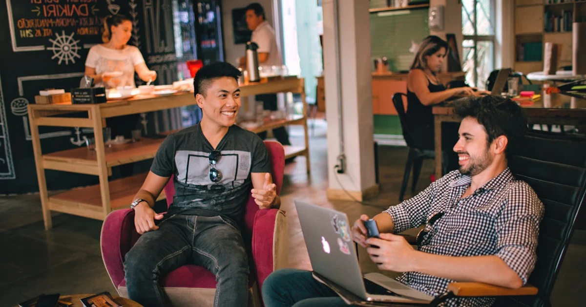 Photograph of Men Having Conversation Seating on Chair